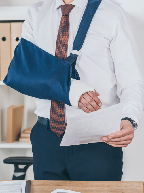 worker with broken arm in bandage standing