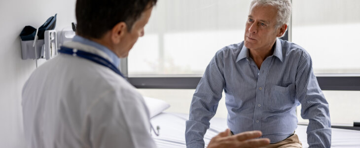 Latin American doctor talking to a patient in a consultaton at his office practice - healthcare and medicine concepts