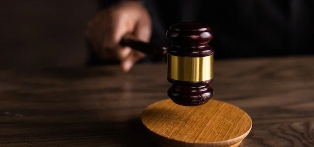 Judge’s gavel being struck on a wooden block.