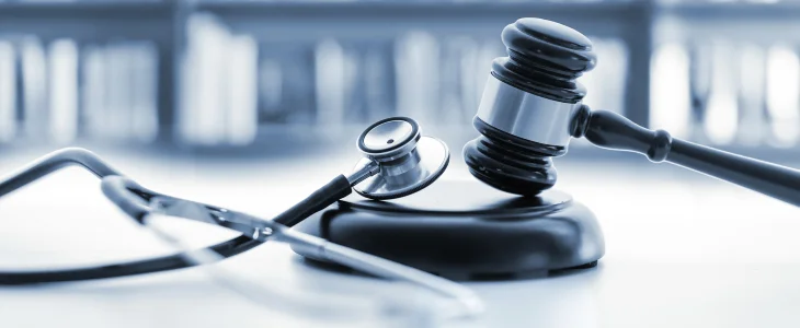 Gavel and mallet next to a stethoscope to represent medical malpractice.