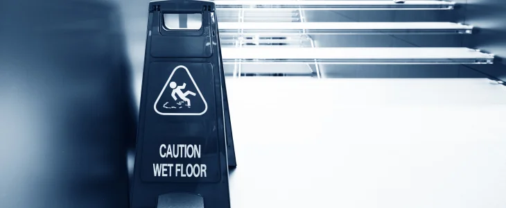 Wet floor sign in front of stairs