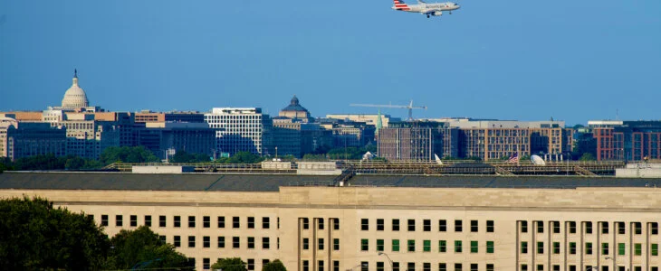 An American Airlines passenger jet on final approach to Reagan National Airport appears to fly over the Pentagon with the U.S. Capitol is the distance.
