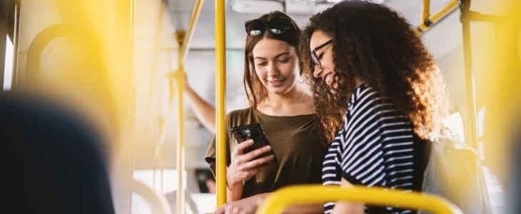 two women on washington d.c. bus looking down at phone